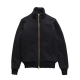 Front of a black turtleneck sweater jacket with a brass zipper going down the entirety of the front of the sweater.