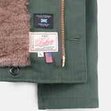 Close-up of a green jacket with brand labels and a zipper
