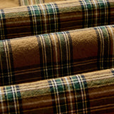Close-up of plaid fabric with brown, green, and beige colors.