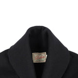 Close-up of a black sweater with a visible label on a white background