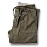 Folded olive green pants on a white background