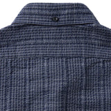 Close up of back of collar buttoned down on blue grid-patterned shirt