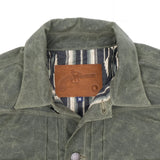 "collar and leather logo patch of the waxed canvas olive western style jacket with southwestern blanket lined body and satin lined sleeves"