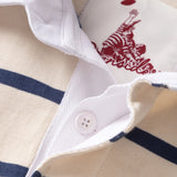 Closeup of hidden placket on an off-white and navy blue striped rugby polo with white rubber button showing.