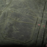 "pocket of the waxed canvas olive western style jacket with southwestern blanket lined body and satin lined sleeves"
