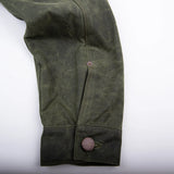 "cuff button on the waxed canvas olive western style jacket with southwestern blanket lined body and satin lined sleeves"