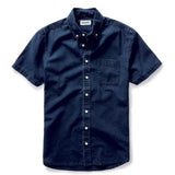 short sleeve oxford collar shirt in a rinsed denim indigo color on a white background.