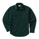 Front of dark green long sleeved button up shirt with a row of small black buttons going down the center and two chest pockets with flaps secured with the same type of buttons.