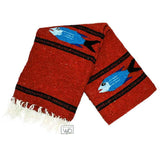 Red woven blanket with blue fish design on a white background