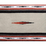 A close-up of a woven textile or rug with a Southwestern geometric pattern, featuring a cream center, black and red borders, and a central red and black diamond motif.