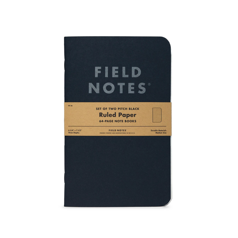 Field Notes notebook with a black cover and brown label on a white background