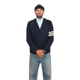 Man wearing a navy cardigan with white stripes, light blue shirt, and jeans on a white background