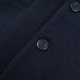 Close-up of a navy blue textured fabric with buttons