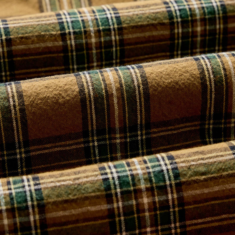 Close-up of plaid fabric with brown, green, and beige colors.