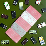 Playing cards and dominoes on a green surface