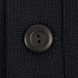 Close-up of a button on a dark textured fabric
