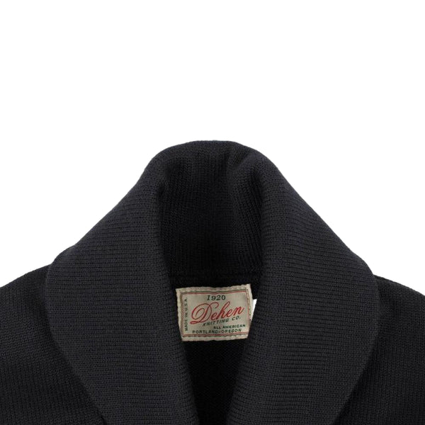 Close-up of a black sweater with a visible label on a white background