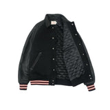 Black varsity jacket with quilted lining on a light gray background