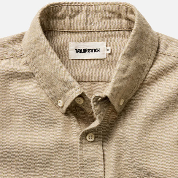 Close-up of a beige shirt with a collar and 'Tailor Stitch' label.