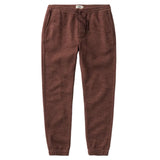 Pair of burgundy tapered pants with a drawstring waist and elastic around the ankles. 