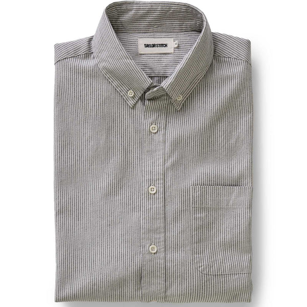 Folded gray and white striped shirt on a white background