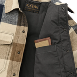 Close up of upper portion of wool jacket that is unbuttoned to show dark inner lining and interior pocket, which is holding a wallet to demonstrate usage. 