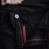Close up of silver-colored zipper, unzipped, on a pair of black canvas pants. At the back of the waistband is a white cloth tag with a red embroidered anchor and the text [Iron and Resin High-Quality Premium Goods] and a small tag indicating the pants pictured are size 32. 