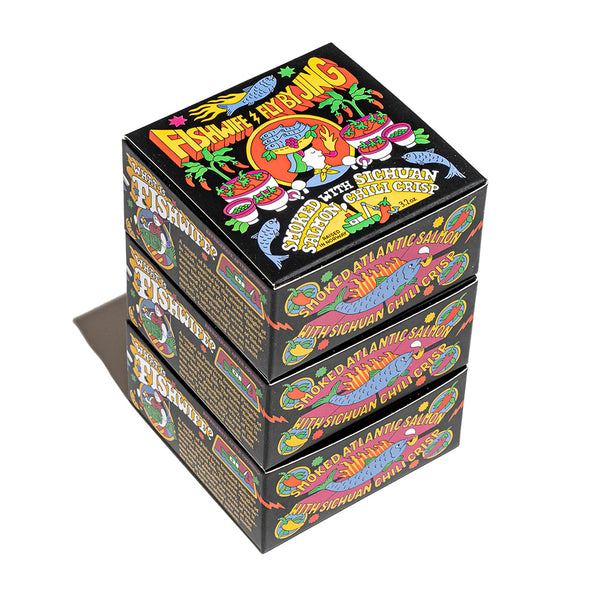 "colorful cartoon covered box containing three tins of smoked salmon with sichuan chili crisp fly by jing sauce'
