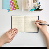 Person writing in houma square diary