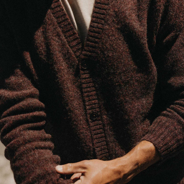 Close-up of a person wearing a brown cardigan with a blurred background