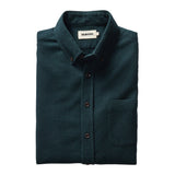"Long sleeved Forest green collared shirt with brown buttons folded"