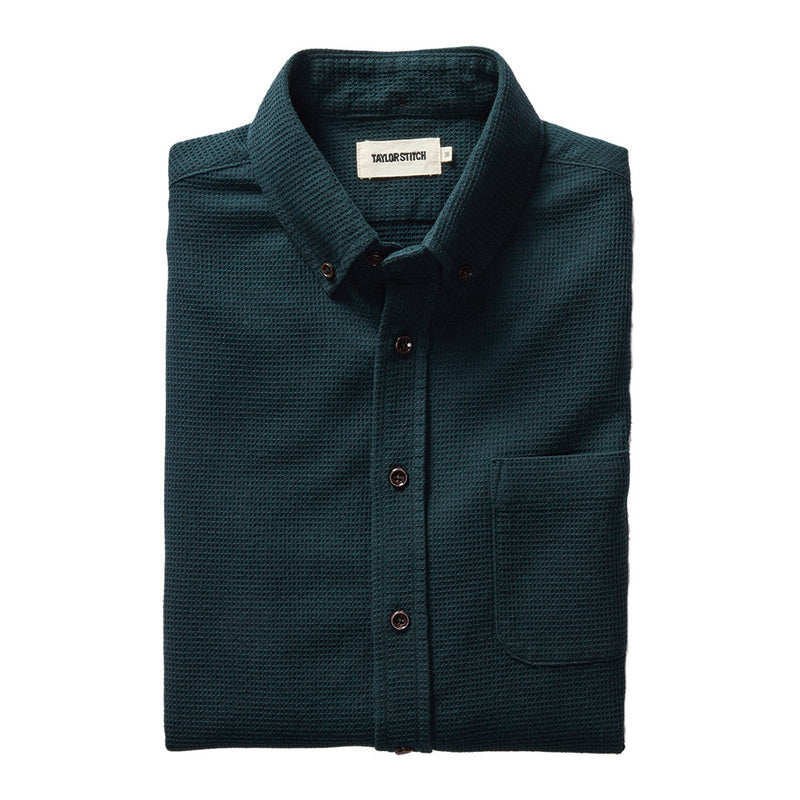 "Long sleeved Forest green collared shirt with brown buttons folded"
