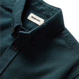 "Long sleeved Forest green collared shirt with brown buttons"