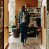 Man wearing dark indigo jeans in a well-styled home