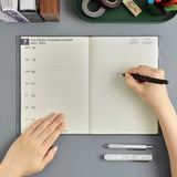 Top down view of open planner being written in 