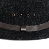 Close up view of four metal grommets and dark brown leather hatband on a charcoal wool hat