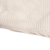 Closeup of bottom hem of ivory thermal shirt