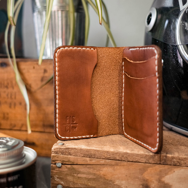A brown leather wallet next to a motorcycle helmet